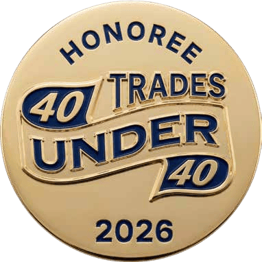 Gold circular medal with blue '40 Under 40' lettering, ribbon accents, and 'Honoree 2026' at the bottom.